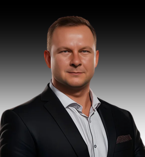 Professional headshot of a man in a black suit and light shirt, neutral gradient background